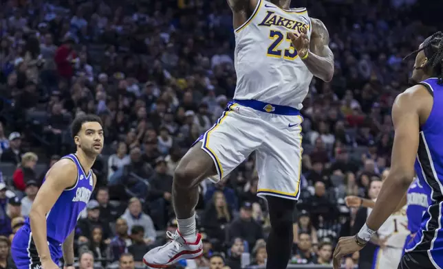 Los Angeles Lakers forward LeBron James (23) draws a foul on Sacramento Kings forward Keegan Murray (13) during the first half of an NBA basketball game, Saturday, Dec. 21, 2024, in Sacramento, Calif. (AP Photo/Sara Nevis)