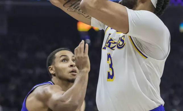 Los Angeles Lakers forward Anthony Davis (3) shoots over Sacramento Kings forward Keegan Murray during the first half of an NBA basketball game, Saturday, Dec. 21, 2024, in Sacramento, Calif. (AP Photo/Sara Nevis)