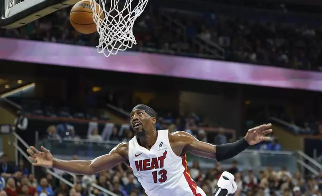 Miami Heat center Bam Adebayo (13) fouls Orlando Magic guard Jalen Suggs, not pictured, during the first half of an NBA basketball game, Thursday, Dec. 26, 2024, in Orlando, Fla. (AP Photo/Kevin Kolczynski)