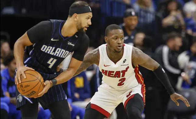 Miami Heat guard Terry Rozier (2) defends Orlando Magic guard Jalen Suggs (4) during the first half of an NBA basketball game, Thursday, Dec. 26, 2024, in Orlando, Fla. (AP Photo/Kevin Kolczynski)