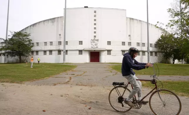 A person rides a bicycle past White Stadium, Wednesday, Sept. 18, 2024, in Boston. (AP Photo/Steven Senne)