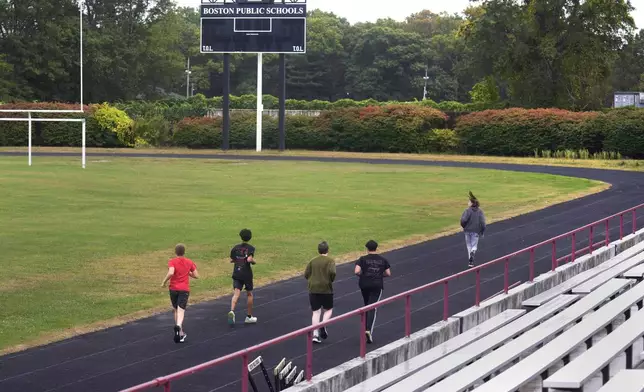 Students from a Boston Latin School physical education class run on the track at White Stadium, Thursday, Sept. 26, 2024, at Franklin Park in Boston. A plan to renovate the aging stadium in Boston for a professional women's soccer team has sparked controversy over concerns it will displace some youth sports and limit access to a public park in one of the city's most diverse neighborhoods. (AP Photo/Charles Krupa)
