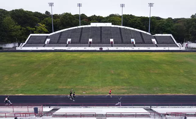 Students from a Boston Latin School physical education class run on the track at White Stadium, Thursday, Sept. 26, 2024, at Franklin Park in Boston. A plan to renovate the aging stadium in Boston for a professional women's soccer team has sparked controversy over concerns it will displace some youth sports and limit access to a public park in one of the city's most diverse neighborhoods. (AP Photo/Charles Krupa)