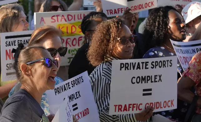 Carla-Lisa Caliga, of Boston, front left, joins with others displaying placards during a rally held to save White Stadium, Wednesday, Sept. 11, 2024, in Boston. (AP Photo/Steven Senne)