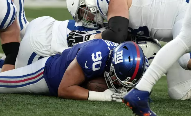 New York Giants defensive end Elijah Garcia (90) recovers a fumble to stop the final drive by the Indianapolis Colts in the second half of an NFL football game Sunday, Dec. 29, 2024, in East Rutherford, N.J. (AP Photo/Seth Wenig)