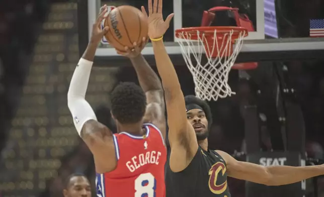 Philadelphia 76ers' Paul George (8) shoots as Cleveland Cavaliers' Jarrett Allen, right, defends during the first half of an NBA basketball game in Cleveland, Saturday Dec. 21, 2024. (AP Photo/Phil Long)