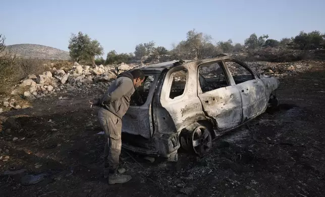 A Palestinian inspects the car that was targeted in an Israeli airstrike that the military said was targeting a militant cell near the West Bank village of Al-Aqaba, Tuesday Dec. 3, 2024. (AP Photo/Majdi Muhammad)