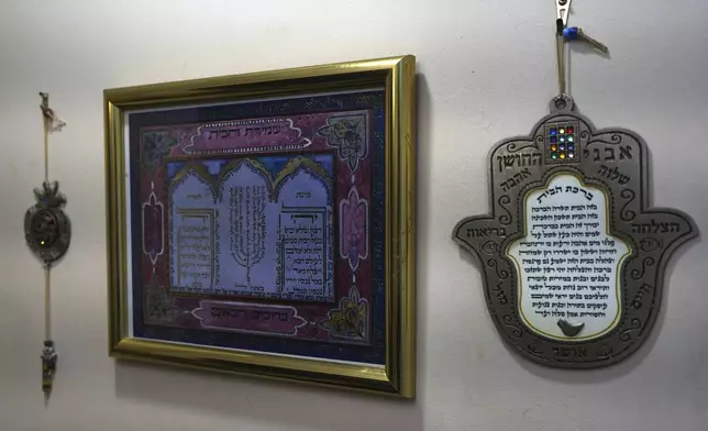 Jewish blessings for the home hang from a wall at the entrance of the Marcus family home at in Teaneck, N.J., on Friday, Dec. 20, 2024. (AP Photo/Luis Andres Henao)