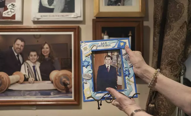 Debbie Marcus shows a framed photo of her son, Dov Marcus, taken at his Bar Mitzvah on display at their family home in Teaneck, N.J., on Friday, Dec. 20, 2024. (AP Photo/Luis Andres Henao)