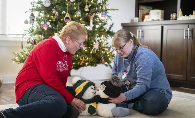 Kathleen Krueger plays with her daughter, Megan, 28, at their home in Racine, Wis., Friday, Dec. 20, 2024. (AP Photo/Andy Manis)