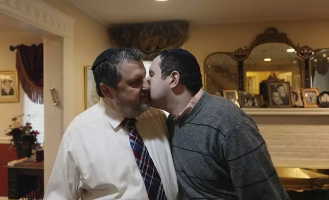 Dov Marcus, right, kisses his father, Robert Marcus, in Teaneck, N.J., on Friday, Dec. 20, 2024. (AP Photo/Luis Andres Henao)