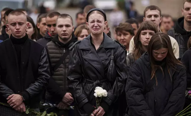 A woman cries during the funeral ceremony of Ihor Kusochek, Ukrainian soldier of the Azov brigade in Bobrovytsia, Chernihiv region, Ukraine, Friday Oct. 4, 2024. (AP Photo/Evgeniy Maloletka)