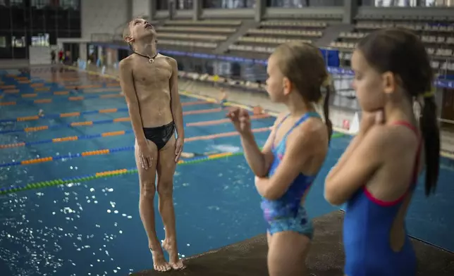 A boy dives into the water during training in Kyiv's Liko Diving School, Wednesday, July 3, 2024. (AP Photo/Alex Babenko)