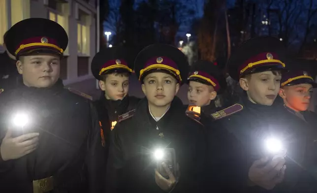 Cadets turn on their flashlights to commemorate 659 Ukrainian children, who were killed during the war with Russia, in a military lyceum on World Children's Day in Kyiv, Ukraine, Wednesday, Nov. 20, 2024. (AP Photo/Efrem Lukatsky)