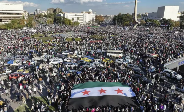 Syrians gather during a celebratory demonstration following the first Friday prayers since Bashar Assad's ouster, in Damascus' central square, Syria, Friday, Dec. 13, 2024. (AP Photo/Ghaith Alsayed)