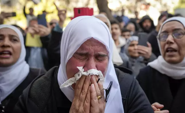 A woman weeps during the funeral of Syrian activist Mazen al-Hamada in Damascus, Thursday, Dec. 12, 2024. Al-Hamad's mangled corpse was found wrapped in a bloody sheet in Saydnaya prison. He had fled to Europe but returned to Syria in 2020 and was imprisoned upon arrival. (AP Photo/Hussein Malla)