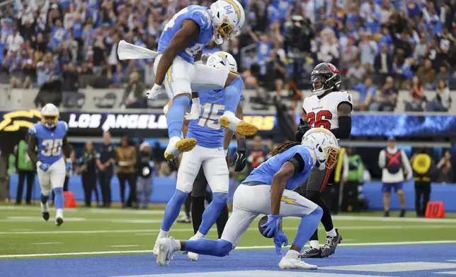 Los Angeles Chargers wide receiver Quentin Johnston (1) celebrates his touchdown catch with teammates during the first half of an NFL football game against the Tampa Bay Buccaneers, Sunday, Dec. 15, 2024, in Inglewood, Calif. (AP Photo/Ryan Sun)