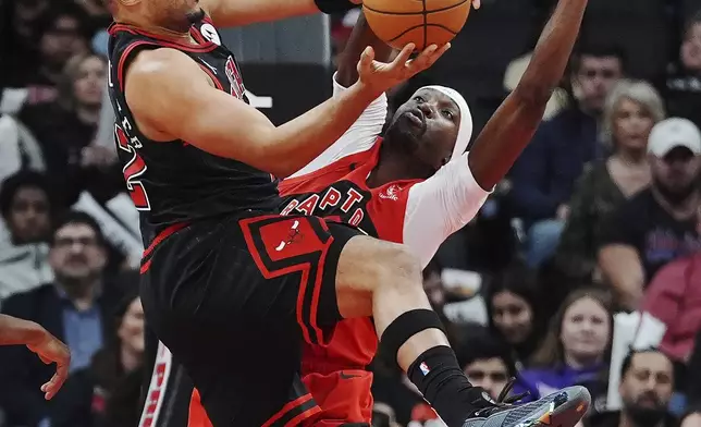 Chicago Bulls' Talen Horton-Tucker, left, leaps as Toronto Raptors' Chris Boucher, right, defends during second-half NBA basketball game action in Toronto, Monday, Dec. 16, 2024. (Frank Gunn/The Canadian Press via AP)