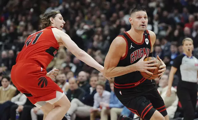 Chicago Bulls' Nikola Vucevic, right, drives past Toronto Raptors' Kelly Olynyk (41) during the first half of an NBA basketball game in Toronto on Monday, Dec. 16, 2024. (Frank Gunn/The Canadian Press via AP)