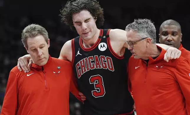 Chicago Bulls' Josh Giddey (3) is helped off the court by medical staff during the second half of an NBA basketball game against the Toronto Raptors in Toronto on Monday, Dec. 16, 2024. (Frank Gunn/The Canadian Press via AP)