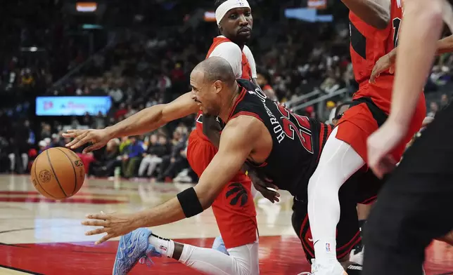 Chicago Bulls' Talen Horton-Tucker (22) makes a diving pass around Toronto Raptors' Chris Boucher (25) during the second half of an NBA basketball game in Toronto on Monday, Dec. 16, 2024. (Frank Gunn/The Canadian Press via AP)