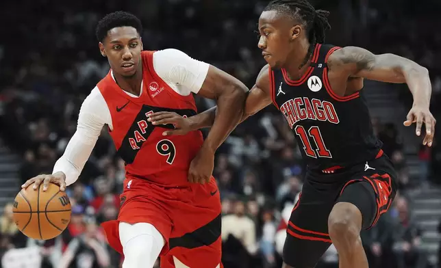 Toronto Raptors' RJ Barrett (9) protects the ball from Chicago Bulls' Ayo Dosunmu (11) during the second half of an NBA basketball game in Toronto on Monday, Dec. 16, 2024. (Frank Gunn/The Canadian Press via AP)