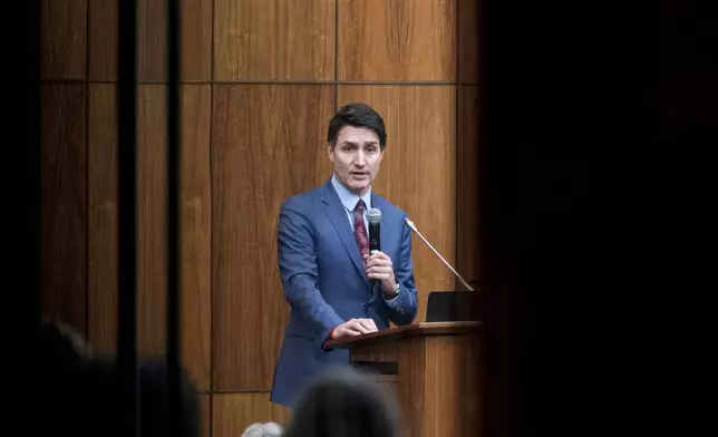 FILE - Canada's Prime Minister Justin Trudeau is pictured through glass as he speaks with members of his caucus in Ottawa, Ontario, Dec. 16, 2024. (Spencer Colby/The Canadian Press via AP, File)