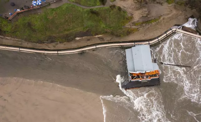 Remnants of a bathroom that fell off the wharf are seen at the mouth of the San Lorenzo River in Santa Cruz, Calif., Tuesday, Dec. 24, 2024. (AP Photo/Nic Coury)