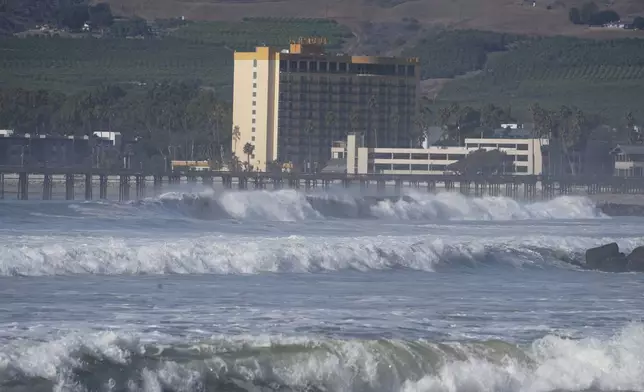 Waves crash past a pier in Ventura, Calif., Tuesday, Dec. 24, 2024. (AP Photo/Damian Dovarganes)