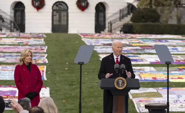 President Joe Biden speaks as first lady Jill Biden listens on the South Lawn of the White House during a ceremony to commemorate World AIDS Day with survivors, their families and advocates, Sunday, Dec. 1, 2024, in Washington. (AP Photo/Manuel Balce Ceneta)