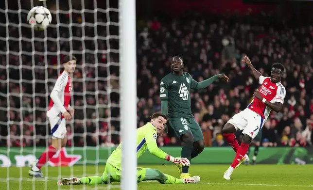 Arsenal's Bukayo Saka, right, scores his side's second goal during the Champions League opening phase soccer match between Arsenal and Monaco, at the Emirates Stadium in London, Wednesday , Dec.11, 2024. (AP Photo/Dave Shopland)