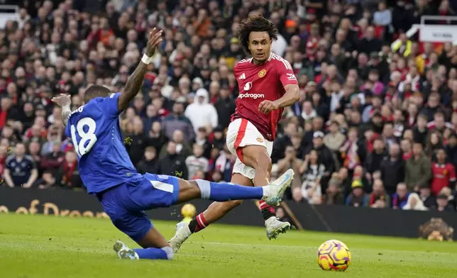 Manchester United's Joshua Zirkzee, right, challenged by Everton's Ashley Young scores during the English Premier League soccer match between Manchester United and Everton at the Old Trafford stadium in Manchester, England, Sunday, Dec. 1, 2024. (AP Photo/Dave Thompson)