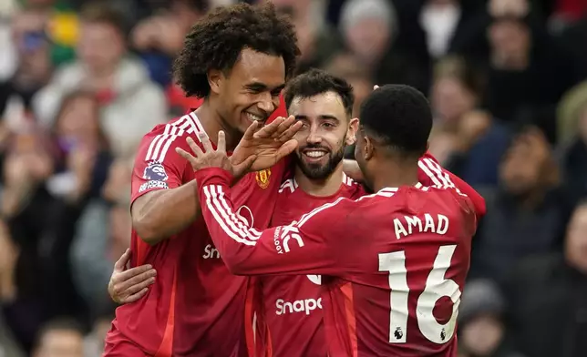 Manchester United's Joshua Zirkzee, left, celebrates with teammates after scoring during the English Premier League soccer match between Manchester United and Everton at the Old Trafford stadium in Manchester, England, Sunday, Dec. 1, 2024. (AP Photo/Dave Thompson)