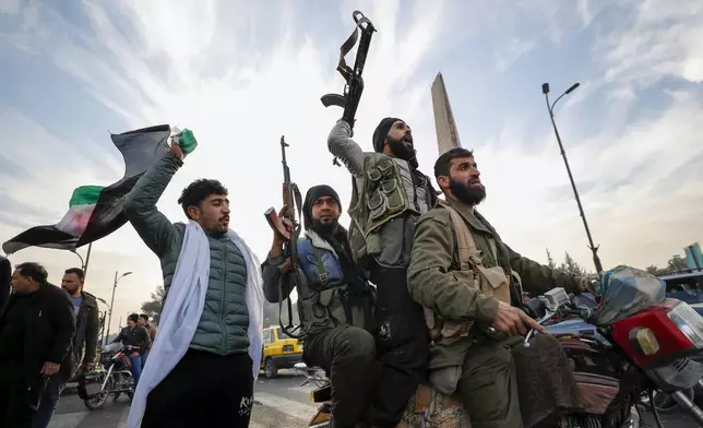 FILE - Syrian opposition fighters celebrate after the government of Bashar Assad collapses in Damascus, Syria, on Dec. 8, 2024. (AP Photo/Omar Sanadiki, File)