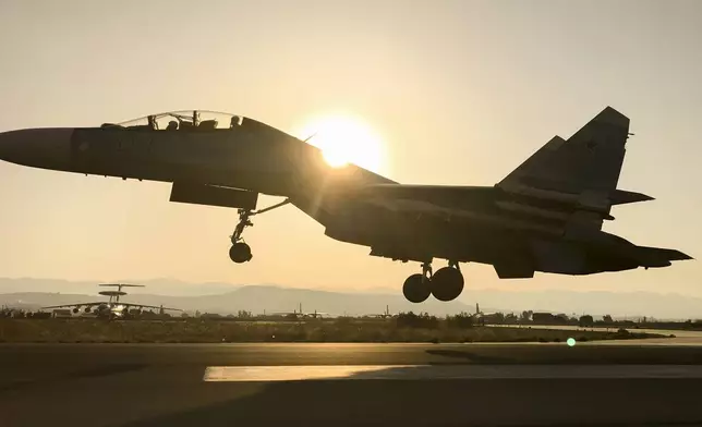 FILE - A Russian military jet lands at sunrise at Hemeimeem air base in Syria on Sept. 12, 2017. (AP Photo/Nataliya Vasilyeva, File)