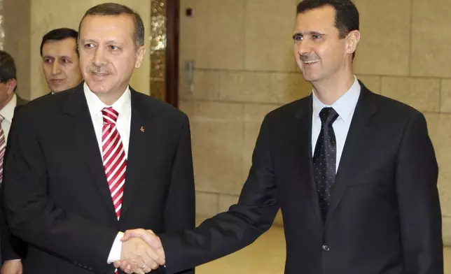 FILE - Syrian President Bashar Assad, right, shakes hands with Turkish leader Recep Tayyip Erdogan at the Ash-Shaeb presidential palace in Damascus, Syria, on April 26, 2008. (AP Photo/Bassem Tellawi, File)