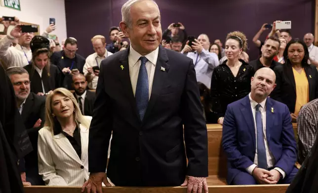 Israeli Prime Minister Benjamin Netanyahu, center, arrives to attend a hearing at the district court for his long-running trial for alleged corruption, in Tel Aviv, Israel, Tuesday, Dec. 10, 2024. (Menahem Kahana/Pool Photo via AP)