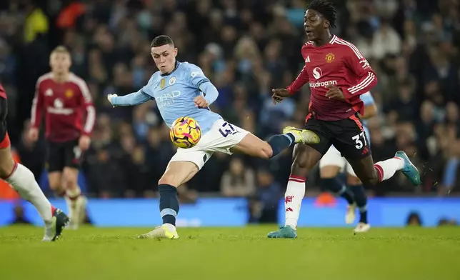 Manchester City's Phil Foden kicks the ball ahead of Manchester United's Kobbie Mainoo during the English Premier League soccer match between Manchester City and Manchester United at the Etihad Stadium in Manchester, Sunday, Dec. 15, 2024. (AP Photo/Dave Thompson)