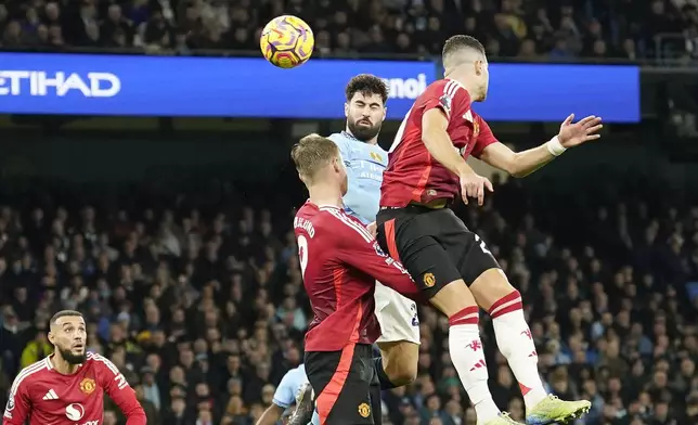 Manchester City's Josko Gvardiol, centre, scores his side's opening goal during the English Premier League soccer match between Manchester City and Manchester United at the Etihad Stadium in Manchester, Sunday, Dec. 15, 2024. (AP Photo/Dave Thompson)