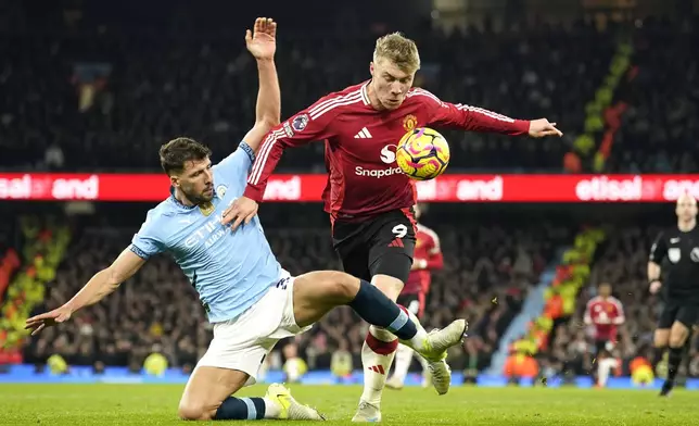 Manchester City's Ruben Dias, left, challenges for the ball with Manchester United's Rasmus Hojlund during the English Premier League soccer match between Manchester City and Manchester United at the Etihad Stadium in Manchester, Sunday, Dec. 15, 2024. (AP Photo/Dave Thompson)