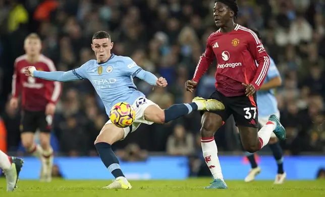 Manchester City's Phil Foden kicks the ball ahead of Manchester United's Kobbie Mainoo during the English Premier League soccer match between Manchester City and Manchester United at the Etihad Stadium in Manchester, Sunday, Dec. 15, 2024. (AP Photo/Dave Thompson)