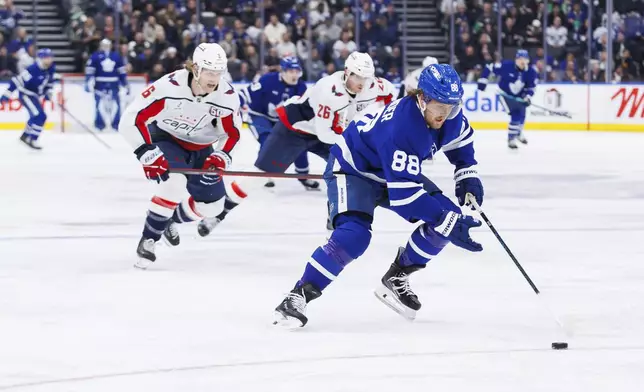 Toronto Maple Leafs right wing William Nylander (88) skates with the puck against the Washington Capitals during second-period NHL hockey game action in Toronto, Friday, Dec. 6, 2024. (Cole Burston/The Canadian Press via AP)