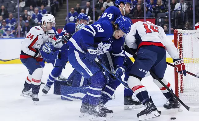 Toronto Maple Leafs left wing Matthew Knies (23) eyes the puck in front of the net during the first period of an NHL hockey game against the Washington Capitals, Friday, Dec. 6, 2024 in Toronto. (Cole Burston/The Canadian Press via AP)