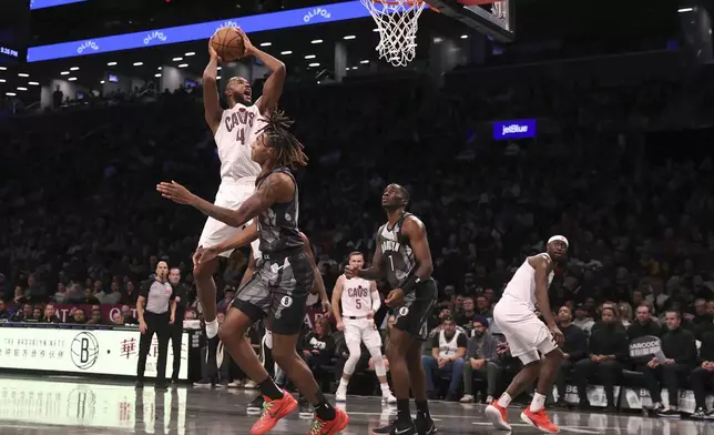 Cleveland Cavaliers' Evan Mobley (4) goes up to shoot during the second half of an NBA basketball game against the Brooklyn Nets, Monday, Dec. 16, 2024, in New York. (AP Photo/Pamela Smith)