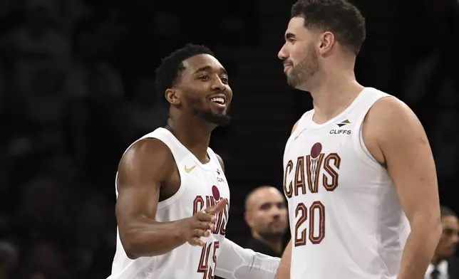 Cleveland Cavaliers' Donovan Mitchell, left, and Georges Niang, right, react after Mitchell scored during the second half of an NBA basketball game against the Brooklyn Nets, Monday, Dec. 16, 2024, in New York. (AP Photo/Pamela Smith)