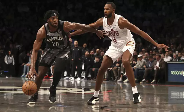 Brooklyn Nets' Day'Ron Sharpe, left, dribbles the ball against Cleveland Cavaliers' Evan Mobley, right, during the first half of an NBA basketball game Monday, Dec. 16, 2024, in New York. (AP Photo/Pamela Smith)