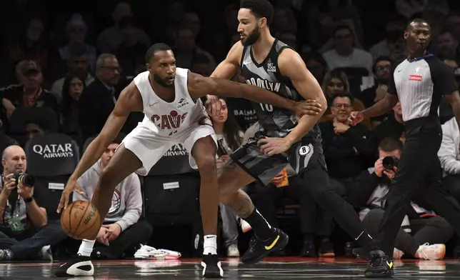 Cleveland Cavaliers' Evan Mobley, left, dribbles the ball against Brooklyn Nets' Ben Simmons, right, during the first half of an NBA basketball game Monday, Dec. 16, 2024, in New York. (AP Photo/Pamela Smith)