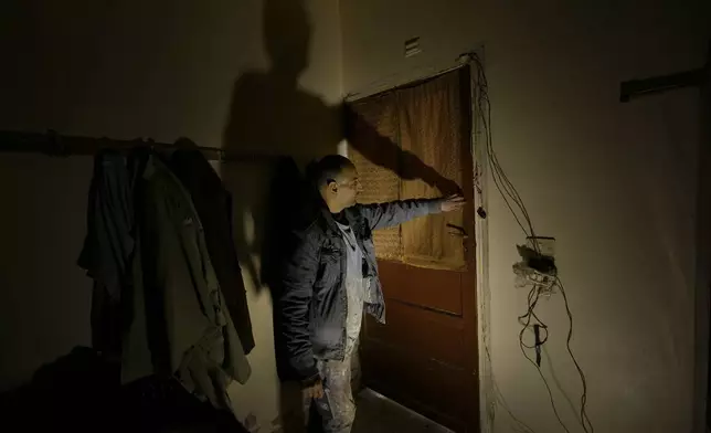 Hussein Arbeeni, 41, shows how he blocked a room door by tapes where 23 people locked themselves inside it to prevent leakage of the sarin struck during a 2013 chemical weapons attack that was blamed on then President Bashar Assad's forces, in Zamalka neighbourhood, on the outskirts of Damascus, Syria, Wednesday, Dec. 25, 2024. (AP Photo/Hussein Malla)