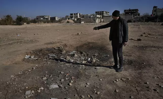 Hassan Arbeeni, 42, shows a crater where a surface-to-surface missile loaded with sarin struck, during a 2013 chemical weapons attack that was blamed on then President Bashar Assad's forces, in Zamalka neighbourhood, on the outskirts of Damascus, Syria, Wednesday, Dec. 25, 2024. (AP Photo/Hussein Malla)