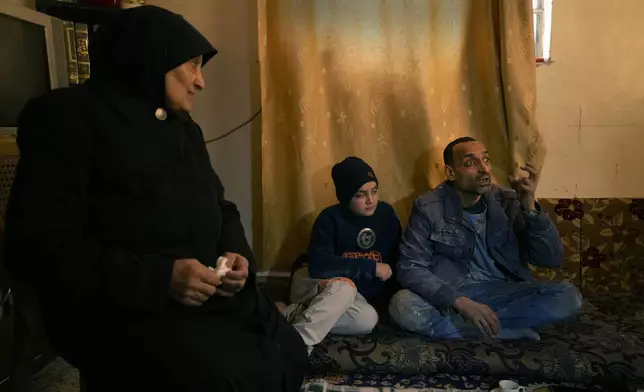 Hussein Arbeeni, 41, right, sits next of his mother mother Khadija Dabbas, 66, left, as he explains how he and his family suffered from the sarin struck during a 2013 chemical weapons attack that was blamed on then President Bashar Assad's forces, in Zamalka neighbourhood, on the outskirts of Damascus, Syria, Wednesday, Dec. 25, 2024. (AP Photo/Hussein Malla)